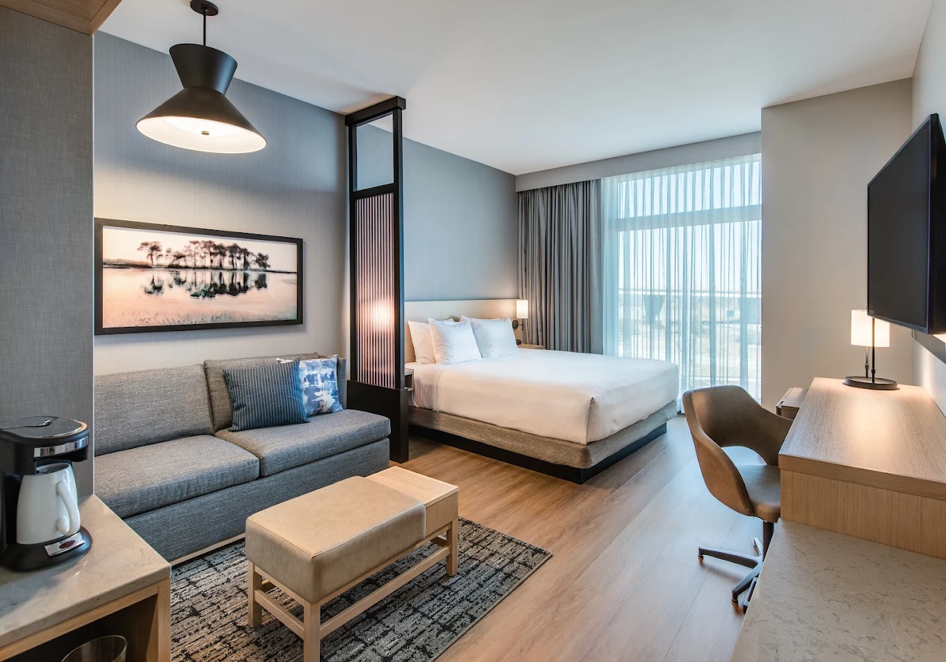 Spacious guest room with king bed, sofa and work desk